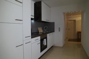 una cocina con armarios blancos y fregadero en Dreams im Erdgeschoss en Koetz 