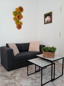 a living room with a couch and a table at Finca el Gaudi, casita Catharina in L'Ampolla
