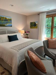 a bedroom with a large bed and a chair at Lovill House Inn in Boone