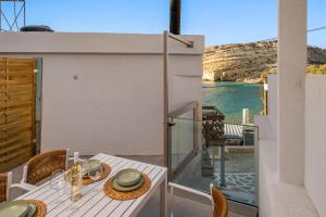 a balcony with a table and chairs and the water at LA MER Suite 2 in Matala