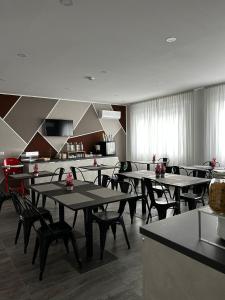 uma sala de jantar com mesas e cadeiras e uma cozinha em Crisvan em Bellaria-Igea Marina