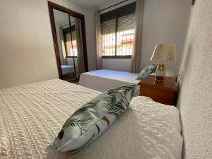 sypialnia z 2 łóżkami i oknem w obiekcie Apartamento Familiar En Barrio Reina Victoria w mieście Huelva