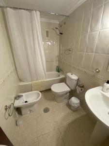 La salle de bains est pourvue de toilettes, d'un lavabo et d'une baignoire. dans l'établissement Apartamento Familiar En Barrio Reina Victoria, à Huelva