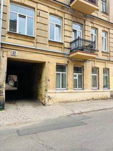 un grand bâtiment avec un garage et un balcon dans l'établissement Cozy studio in Sv Stepono g., à Vilnius