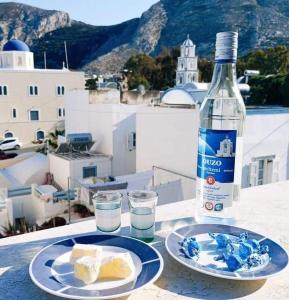 a bottle of water and two plates of cheese and water glasses at Rodi Apartment 2 in Kamari