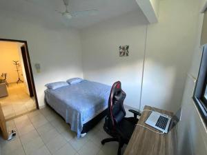 a bedroom with a bed and a desk with a laptop at HERMOSO DPTO DE 2 DORMITORIOS CON GARAGE PRIVADO in San Lorenzo