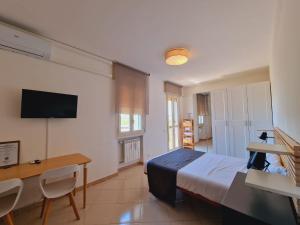 Dormitorio con cama, escritorio y TV en Guest House DEA OPI en Roma