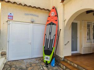 uma prancha de surf encostada a um edifício com garagem em Casa Sebastian em L'Escala