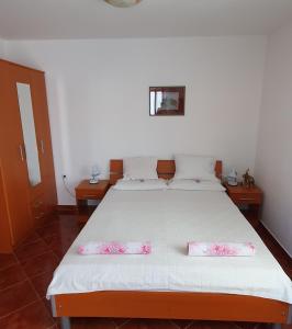 a bedroom with a bed with two pillows on it at Apartments Maxim in Tivat