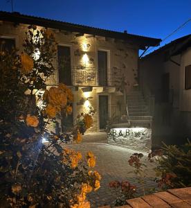 a building with flowers in front of it at night at B&B FANCHETTI 1938 in Sondrio