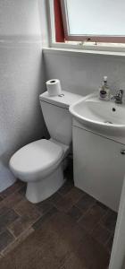 a bathroom with a white toilet and a sink at No 26 rooms in Inverness