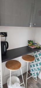 a kitchen with two stools in front of a counter at No 26 rooms in Inverness