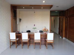 a dining room with a table and white chairs at Cahaya Losmen Sragen Syariah in Sragen