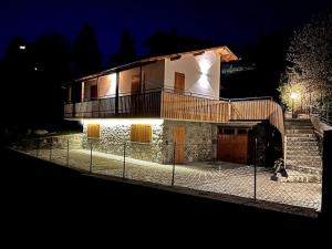 una casa con una valla delante de ella por la noche en Baitèl - Tra il cielo e le Alpi, en Gromo