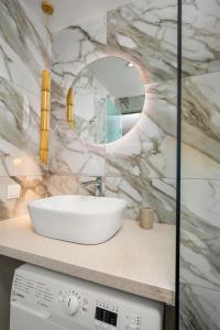 a bathroom with a white sink and a mirror at LA MER Suite 2 in Matala