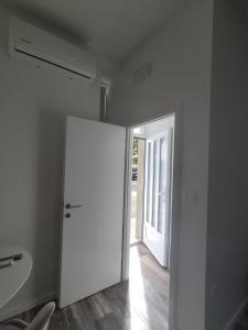 a room with a white door and a hallway at Studio apartman Mara in Imotski