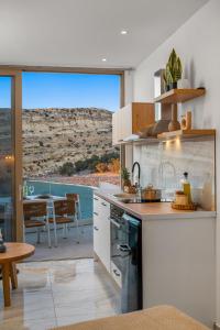 eine Küche mit Blick auf eine Terrasse mit einem Tisch in der Unterkunft LA MER Suite 2 in Matala