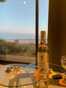 een fles wijn op een glazen tafel met een raam bij Cabane CELESTE Aigues-Mortes in Aigues-Mortes