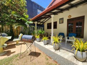 a patio with plants and a grill in front of a house at Mango Villa in Hikkaduwa