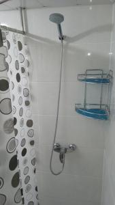 a shower with a shower head in a bathroom at Begzod's house in Samarkand
