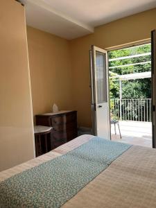 een slaapkamer met een bed en een deur naar een balkon bij Il Ruscello di Casa Teresa in Positano