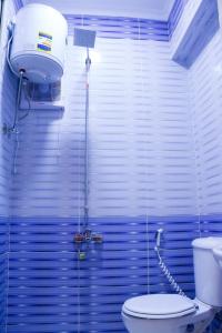 uma casa de banho azul com um WC e uma luz em ستديو مفروش - غرفة فندقيه - للايجار Studios - Room em Cidade 6 de Outubro