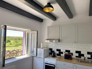 uma cozinha com uma janela, um lavatório e um fogão em La Casa di Nonno em Belej