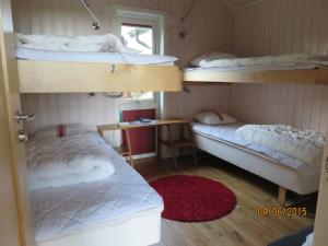 um quarto com 3 beliches e um tapete vermelho em Enebackens Kraftkälla em Tvååker