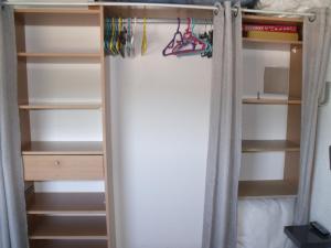 a closet with a curtain and some shelves at Appartement T2, Climatisé, 3 étoiles, 40m2 ,parking privé, Mer 300m, Wifi, Piscines, très propre, Ascenseurs, en étage in Le Grau-du-Roi