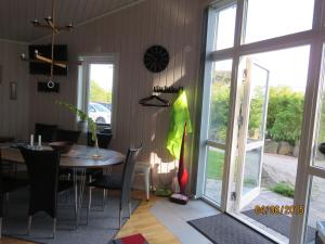 a dining room with a table and a glass door at Enebackens Kraftkälla in Tvååker