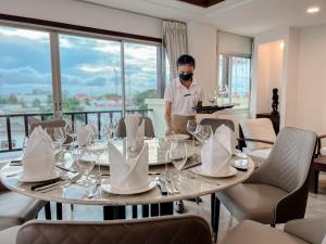 a man wearing a mask standing at a table with wine glasses at City Inn Vientiane in Vientiane