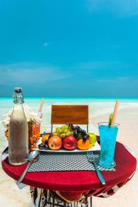 einen Tisch mit einem Teller Essen am Strand in der Unterkunft Dhoani Maldives Guesthouse in Kendhoo