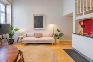 uma sala de estar com um sofá branco e uma mesa em HÔTELS &ASPA em Estoril