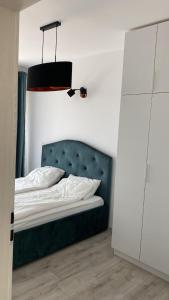ein Schlafzimmer mit einem Bett mit einem grünen Kopfteil und einer Lampe in der Unterkunft Columna residence in Floreşti