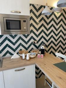 a kitchen with a counter top with a microwave at Oleander Apartment in Castellammare di Stabia