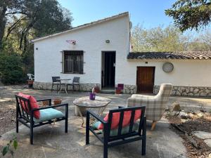 eine Terrasse mit Stühlen und einem Tisch vor einem Haus in der Unterkunft Can Ginesta Muy feliz&tranquilo in Barcelona