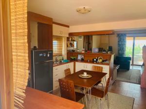 a kitchen with a table and a black refrigerator at BOKAS EXOTIC HOUSE in Tragána