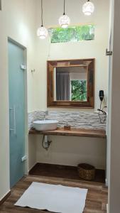 a bathroom with a sink and a mirror at Flor de Lis Chalés in Paraty
