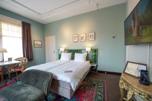Cette chambre comprend un grand lit et une chaise. dans l'établissement Villa Magnolia, à Oostkapelle