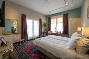 - une chambre avec un grand lit blanc dans l'établissement Villa Magnolia, à Oostkapelle