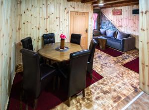 a dining room with a table and chairs and a couch at Apartment Country Villa MMMM-1-Camp Scepanovic in Mojkovac