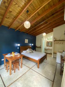 1 dormitorio con cama y mesa de madera en Flor de Lis Chalés, en Paraty