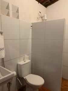 a white bathroom with a toilet and a sink at Estancia Vale das Flores in Pacoti