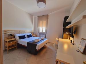 um pequeno quarto com uma cama e uma secretária em Guest House DEA OPI em Roma