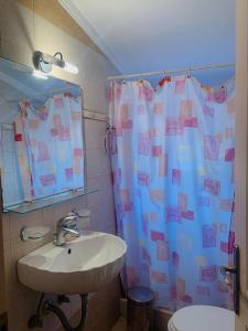 a bathroom with a sink and a shower curtain at BOKAS EXOTIC HOUSE 