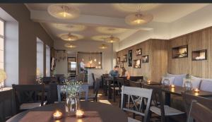 a restaurant with tables and chairs and people in the background at Inselsünn Spiekeroog in Spiekeroog