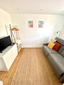 a living room with a couch and a flat screen tv at Joli Studio proche Mer et Digue de Wimereux in Wimereux +3 photos