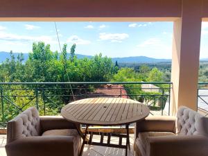 a table and chairs on a balcony with a view at BOKAS EXOTIC HOUSE in Tragána +12 photos
