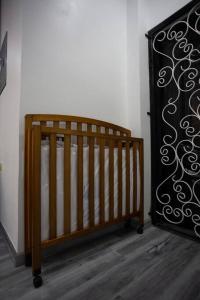 - un lit bébé en bois dans une chambre située à côté d'un mur dans l'établissement Mary's Hill Tropical Oasis, à Maryʼs Hill