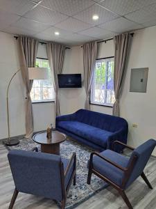 uma sala de estar com um sofá azul e cadeiras em Mary's Hill Tropical Oasis em Maryʼs Hill
